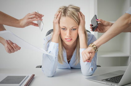 Burnout, junge Frau wird mit Arbeit und Terminen im Büro überschüttet