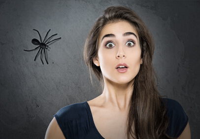 Phobie, Eine junge Frau fürchtet sich vor einer Spinne, die sich ihr nähert